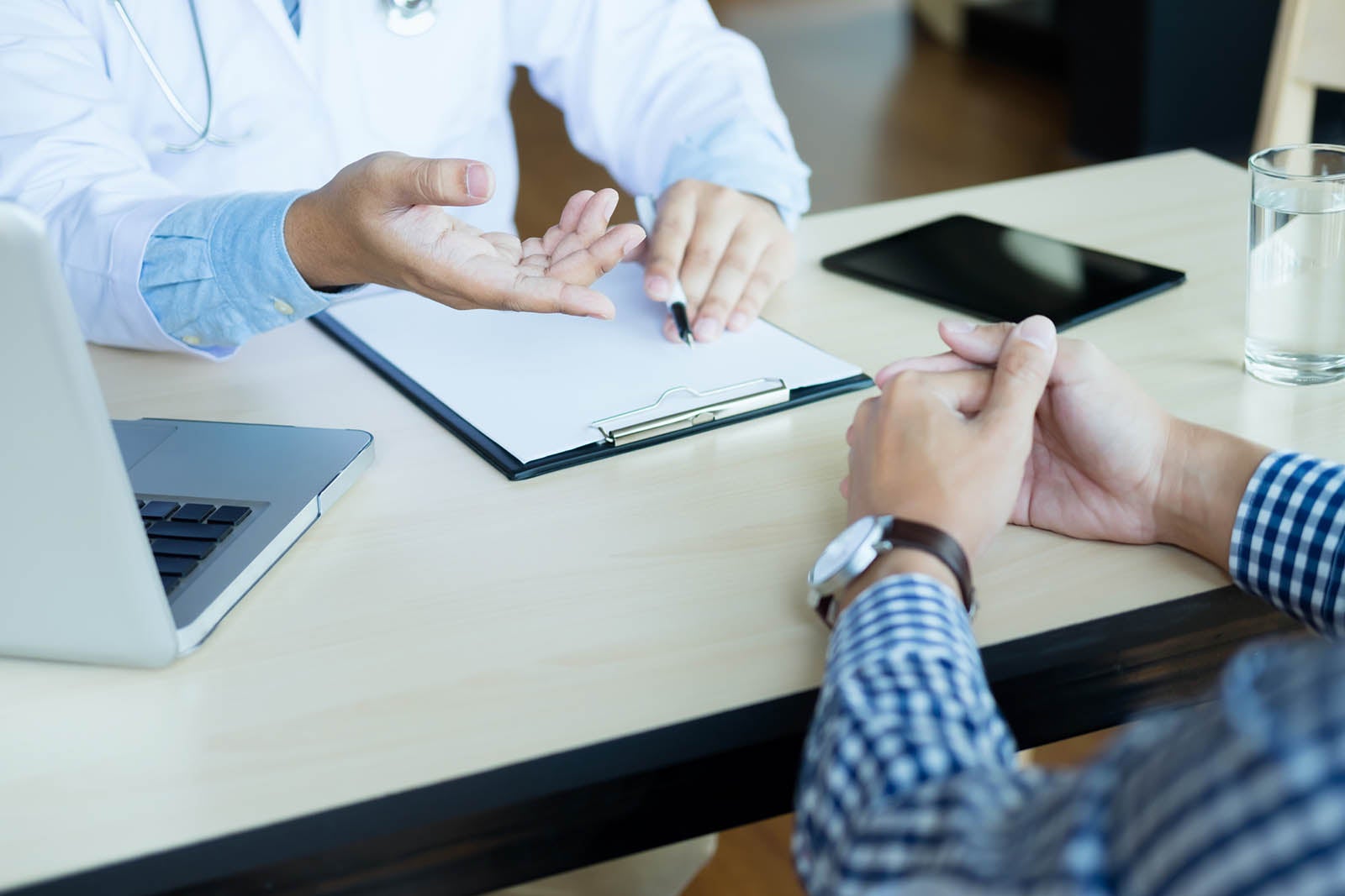 A physician and patient having a discussion at desk.