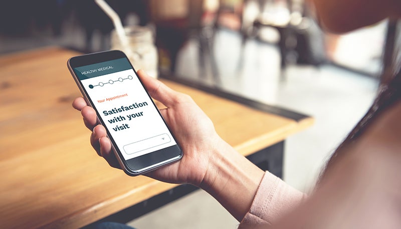 Woman using smart phone in cafe to take a survey