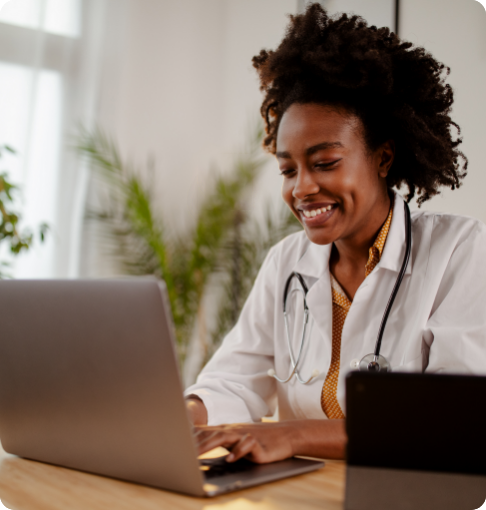 Female doctor looking at analytics on laptop computer and smiling