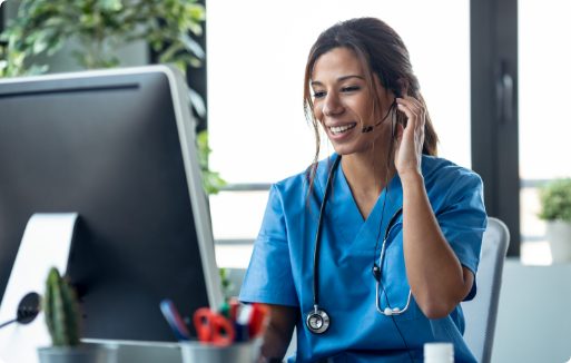 Nurse talking on headset while working on computer at front desk