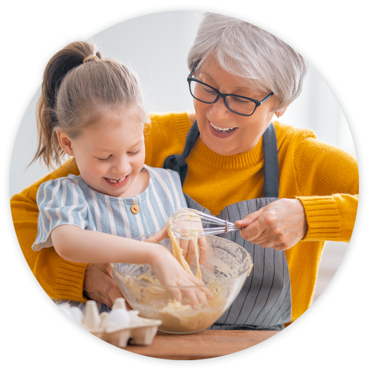 Grandmother smiling and baking with happy granddaughter