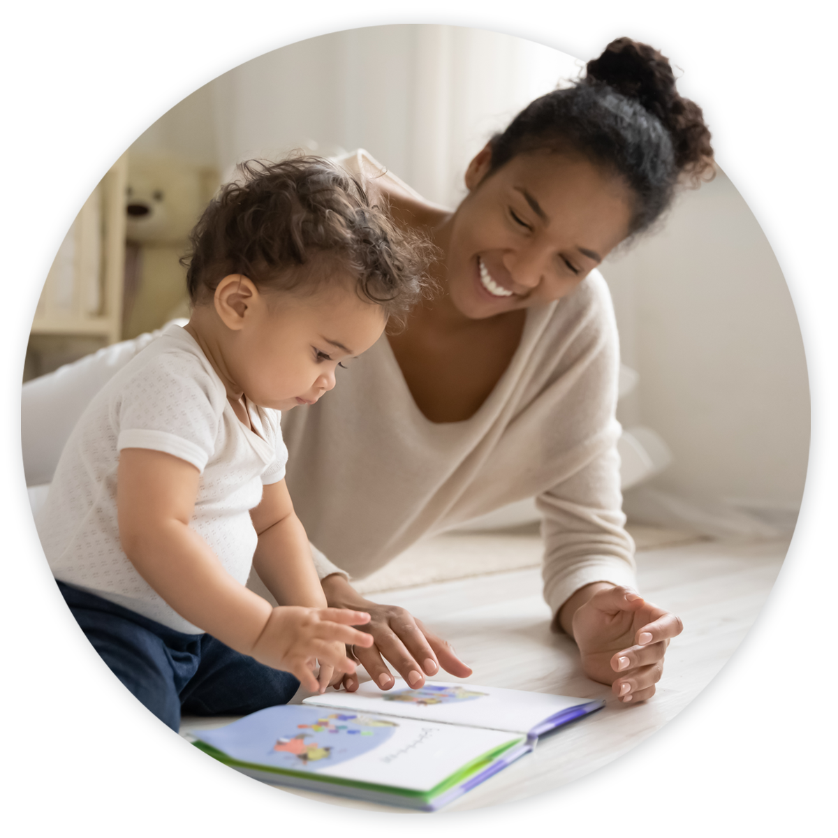 Mother and toddler laying on floor and engaging with book