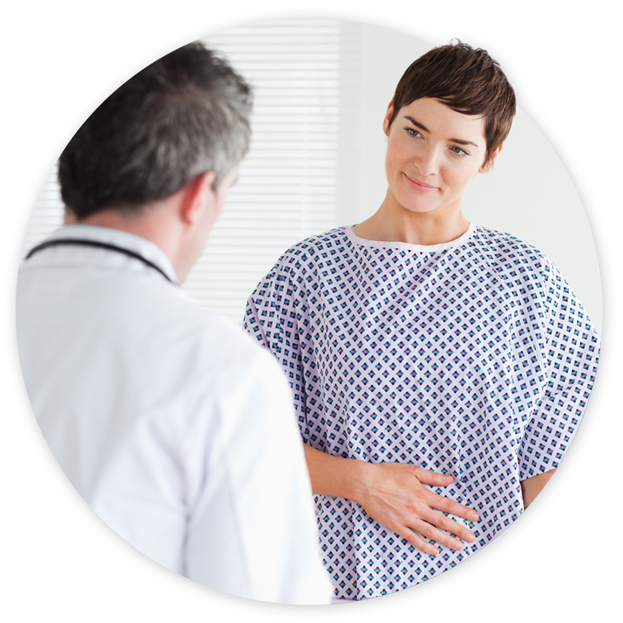 Female patient in hospital gown talking with doctor