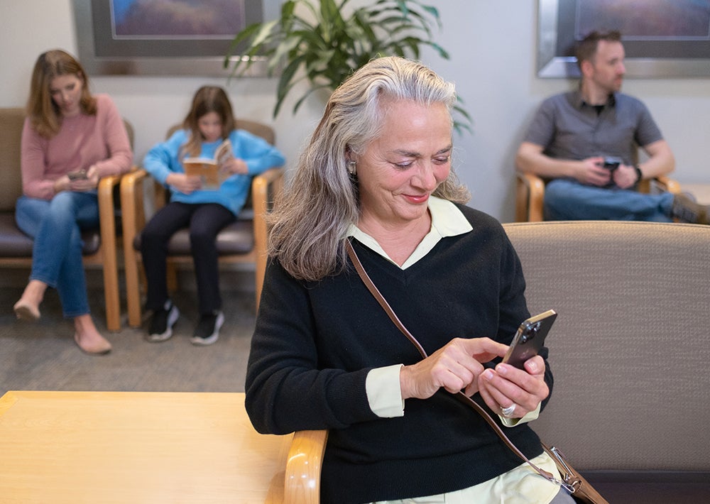 Woman looking at phone in waiting room