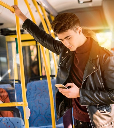Teenage boy on bus looking at phone