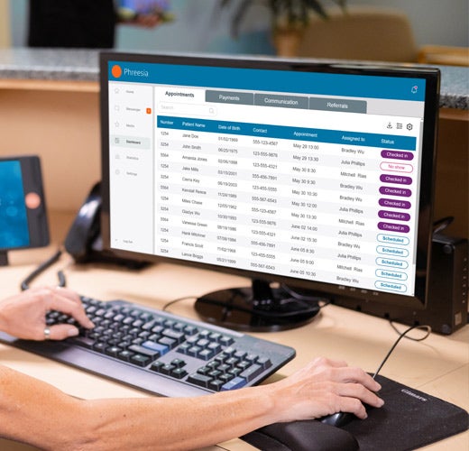 worker-computer Front desk using Phreesia on computer