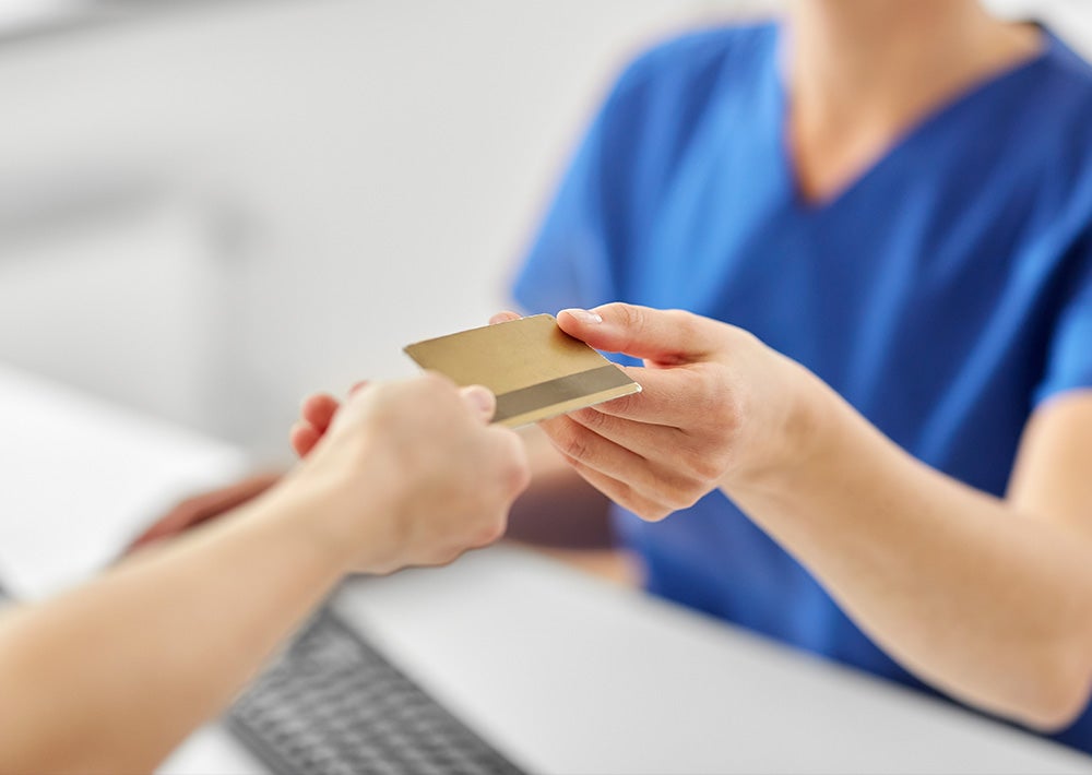 front-desk worker collecting a payment from a patient