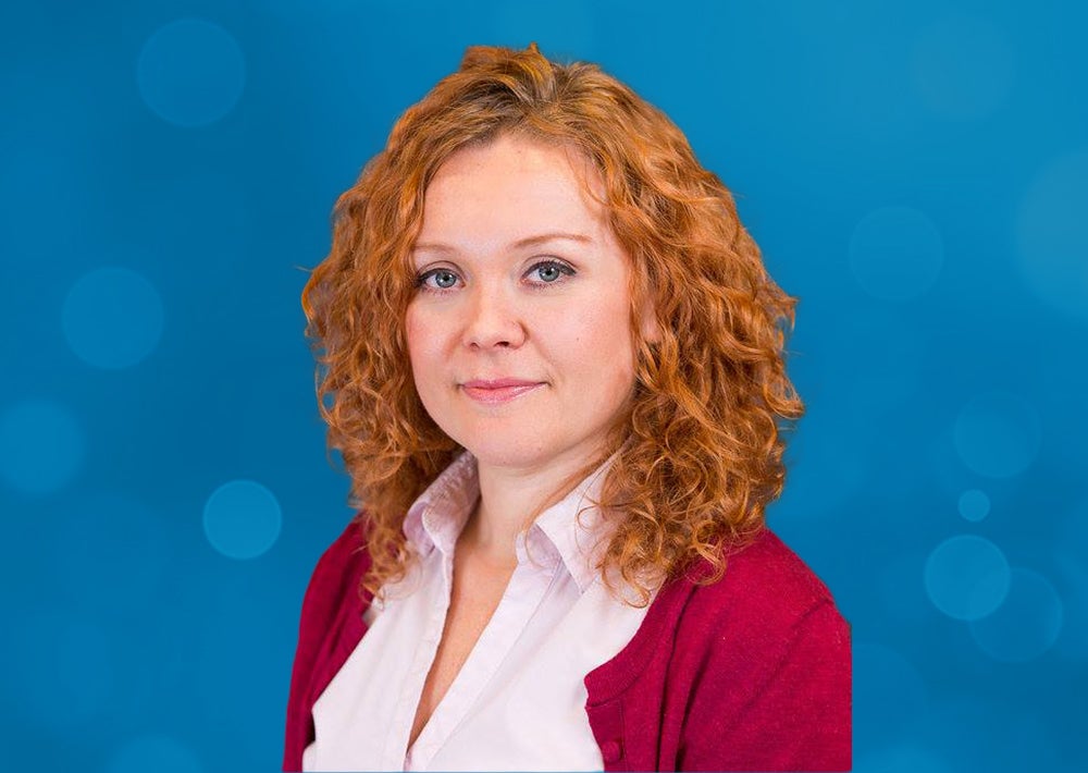 A woman's headshot over a blue background.