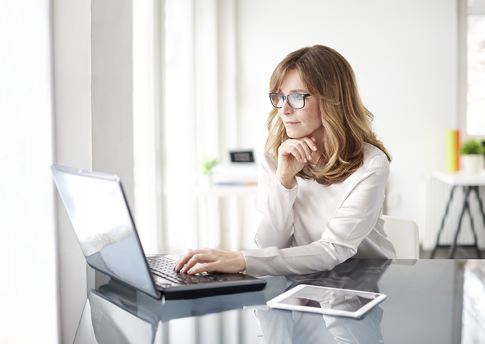 Woman sitting at laptop, smiling