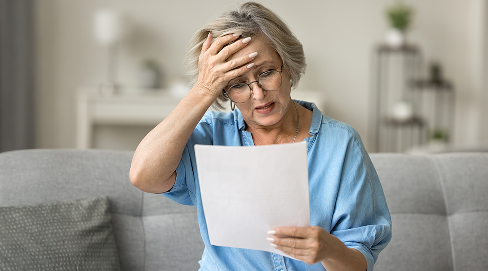 Woman stressed holding a bill