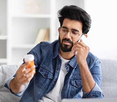 PhreesiaVoiceAI-tab4 Man on phone looking at prescription bottle