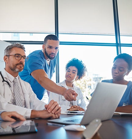 Doctors and nurses crowded around laptop screen
