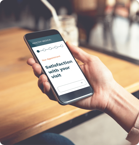 Person holding smartphone displaying a "Healthy Medical" satisfaction survey with a progress indicator and the text "Satisfaction with your visit