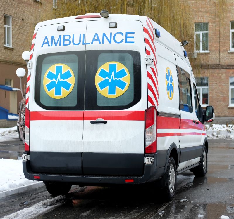 ambluance in front of building with snow on ground