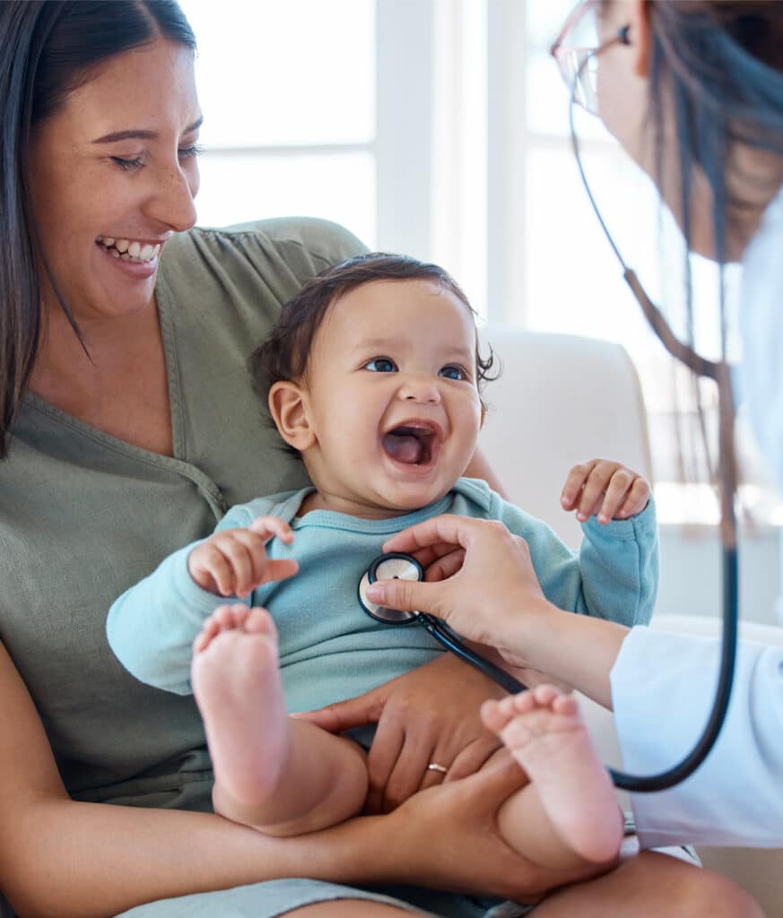 mom holding baby while provider uses stethoscope to listen to heart